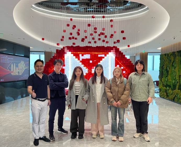 A group of people standing in a roomAI-generated content may be incorrect.