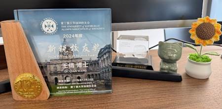A glass plaque with a picture of a building in the backgroundDescription automatically generated